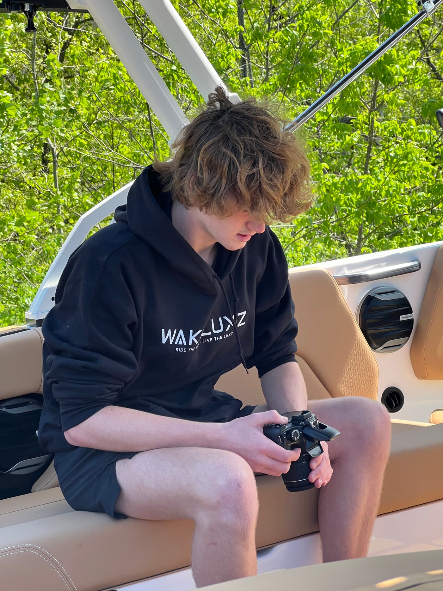 Collin Murphey sitting in the MasterCraft holding a camera