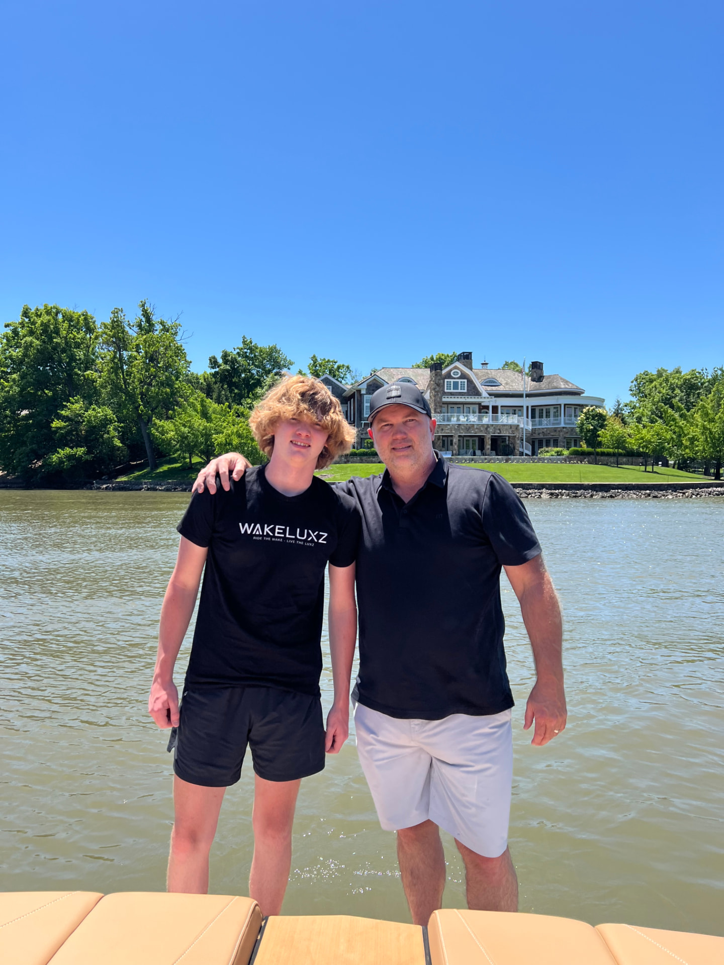 Garrison and Collin Murphey on the water in front of a lake home
