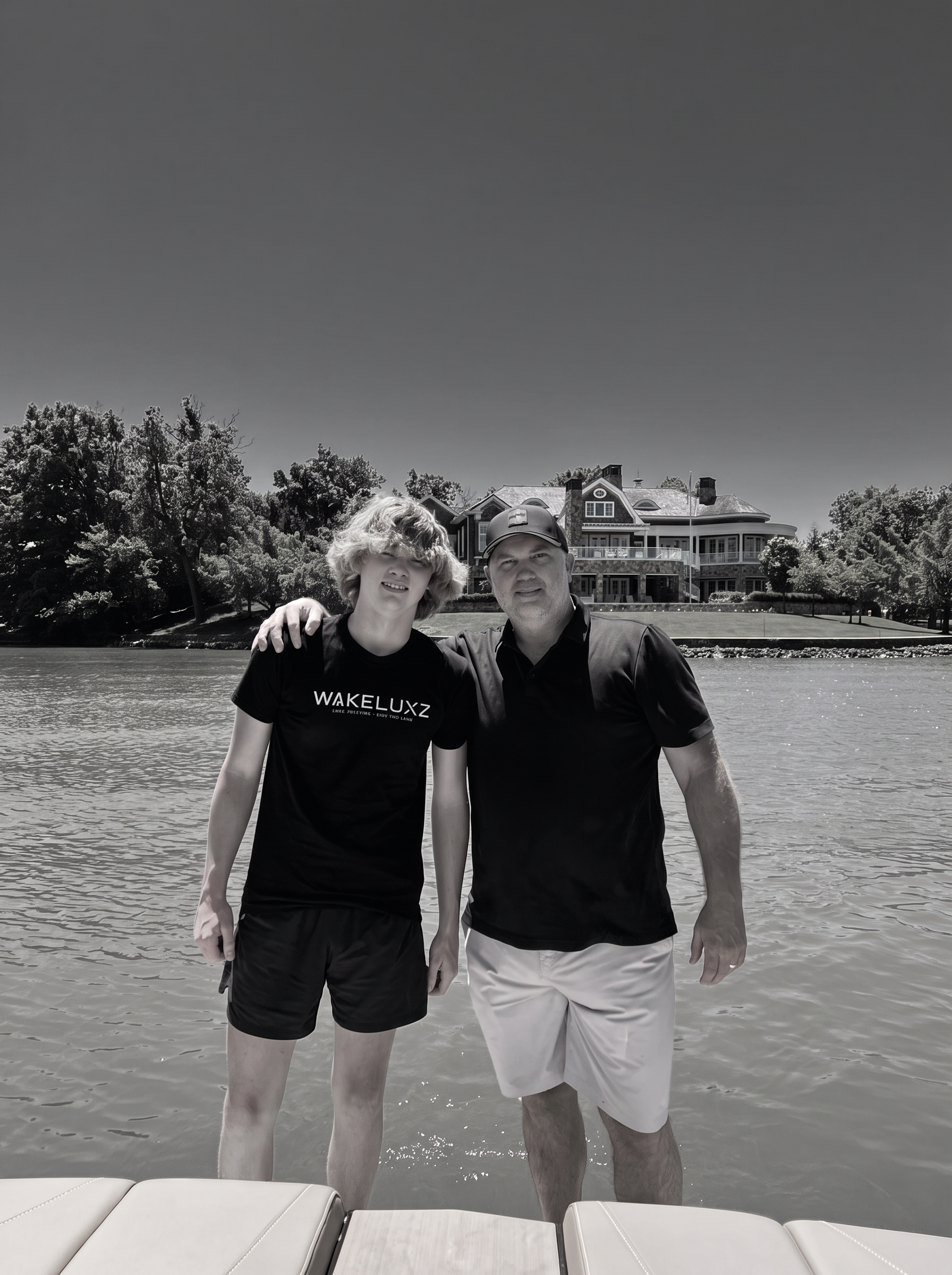 Garrison and Collin Murphey on the water in front of a lake home