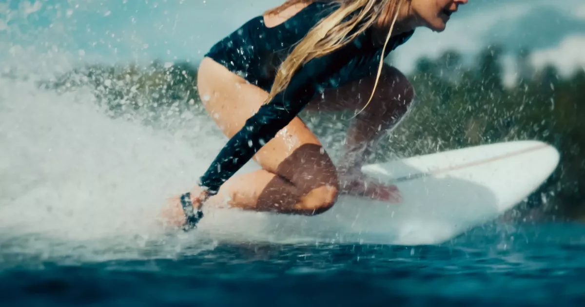 Rider low on a LIND board driving through a turn on open water