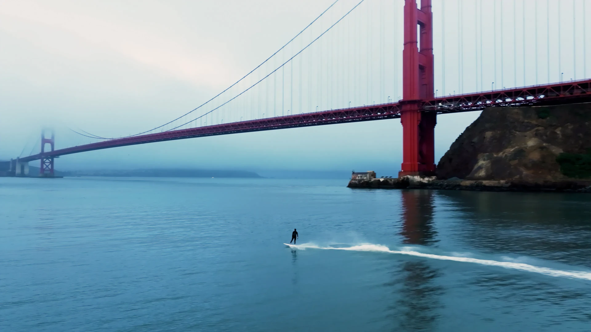 Rider on an electric surfboard on dark open water