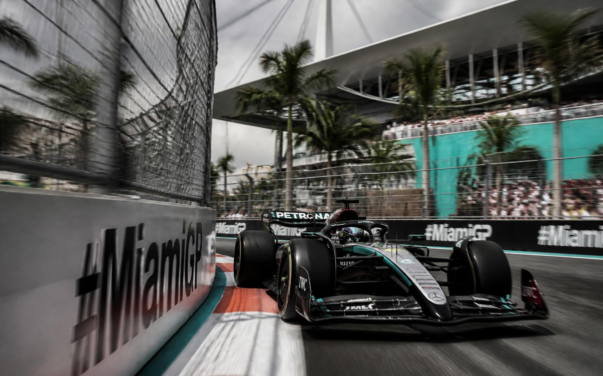 Formula 1 car cornering between barriers and catch fencing at the Miami circuit