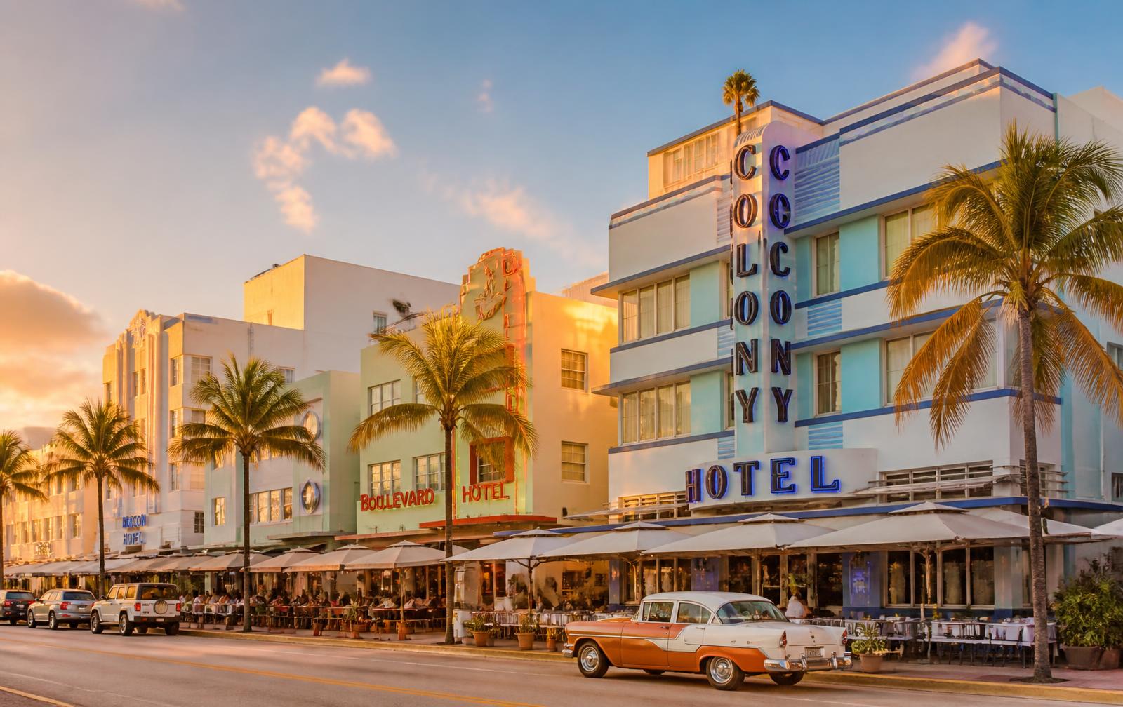 Art deco hotels along a palm-lined South Beach street at golden hour