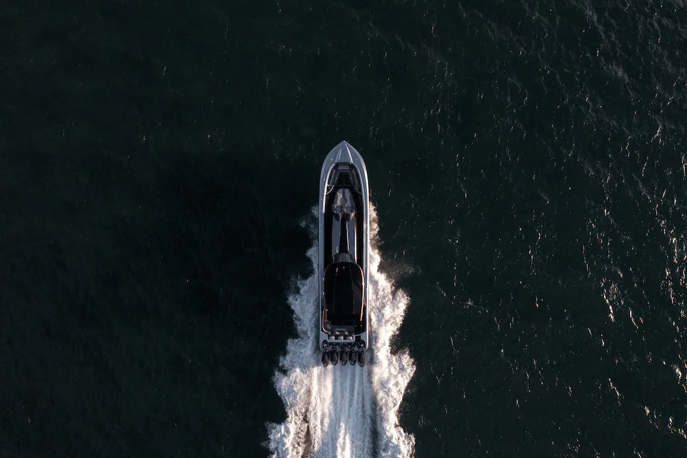 Aerial view of an MTI performance boat running across dark water
