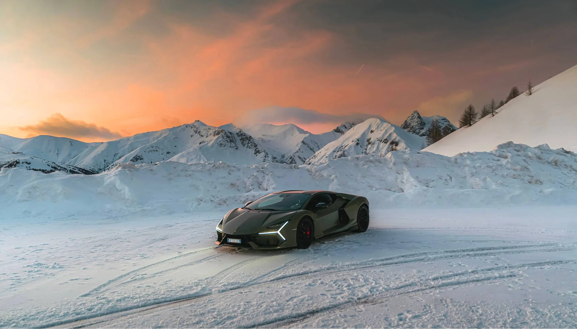 Lamborghini Revuelto crossing a snow-covered mountain landscape
