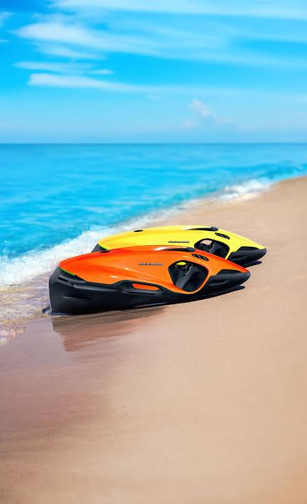 Two SEABOBs resting on the sand at the water’s edge