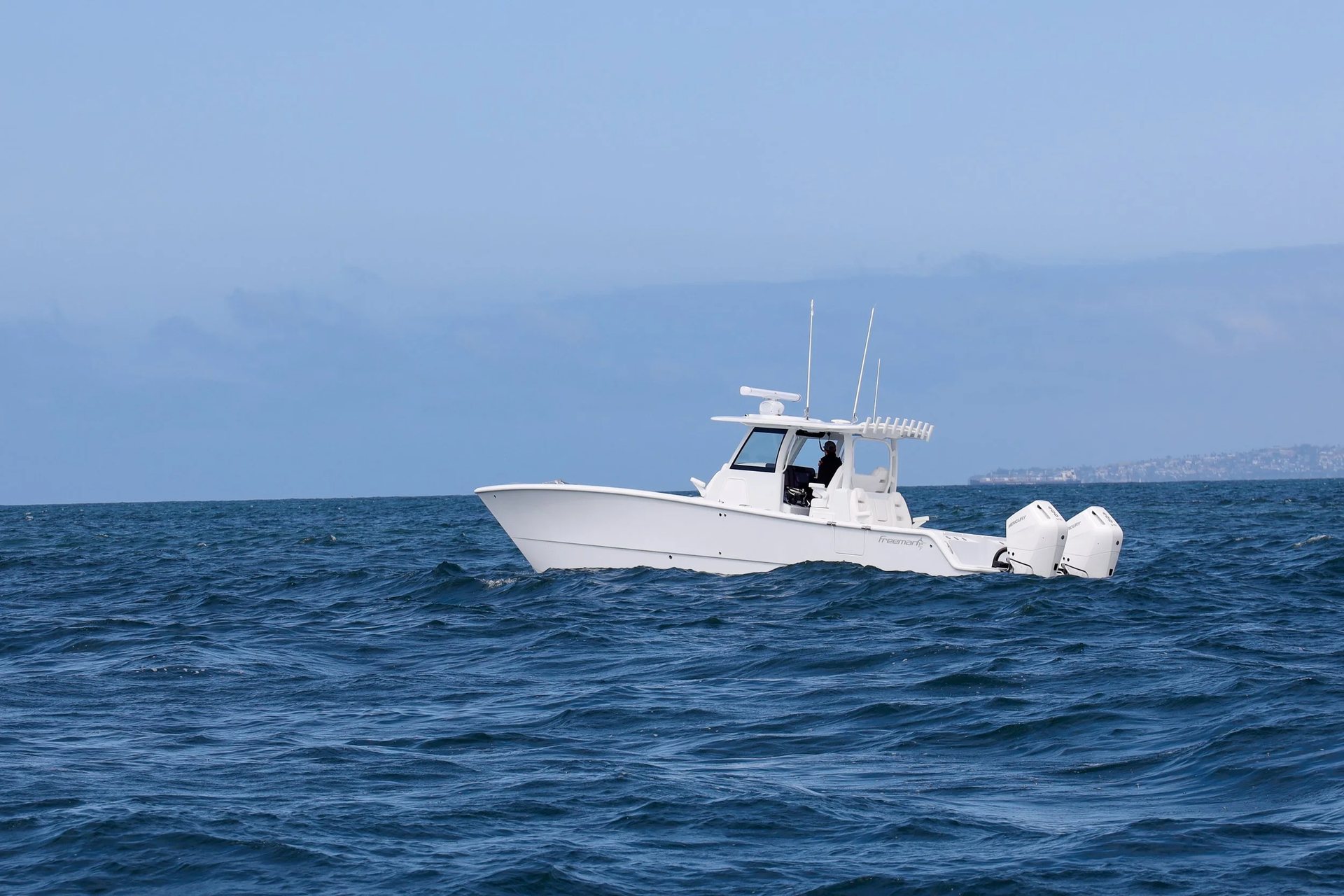 Freeman catamaran drifting on glassy blue water in late afternoon light