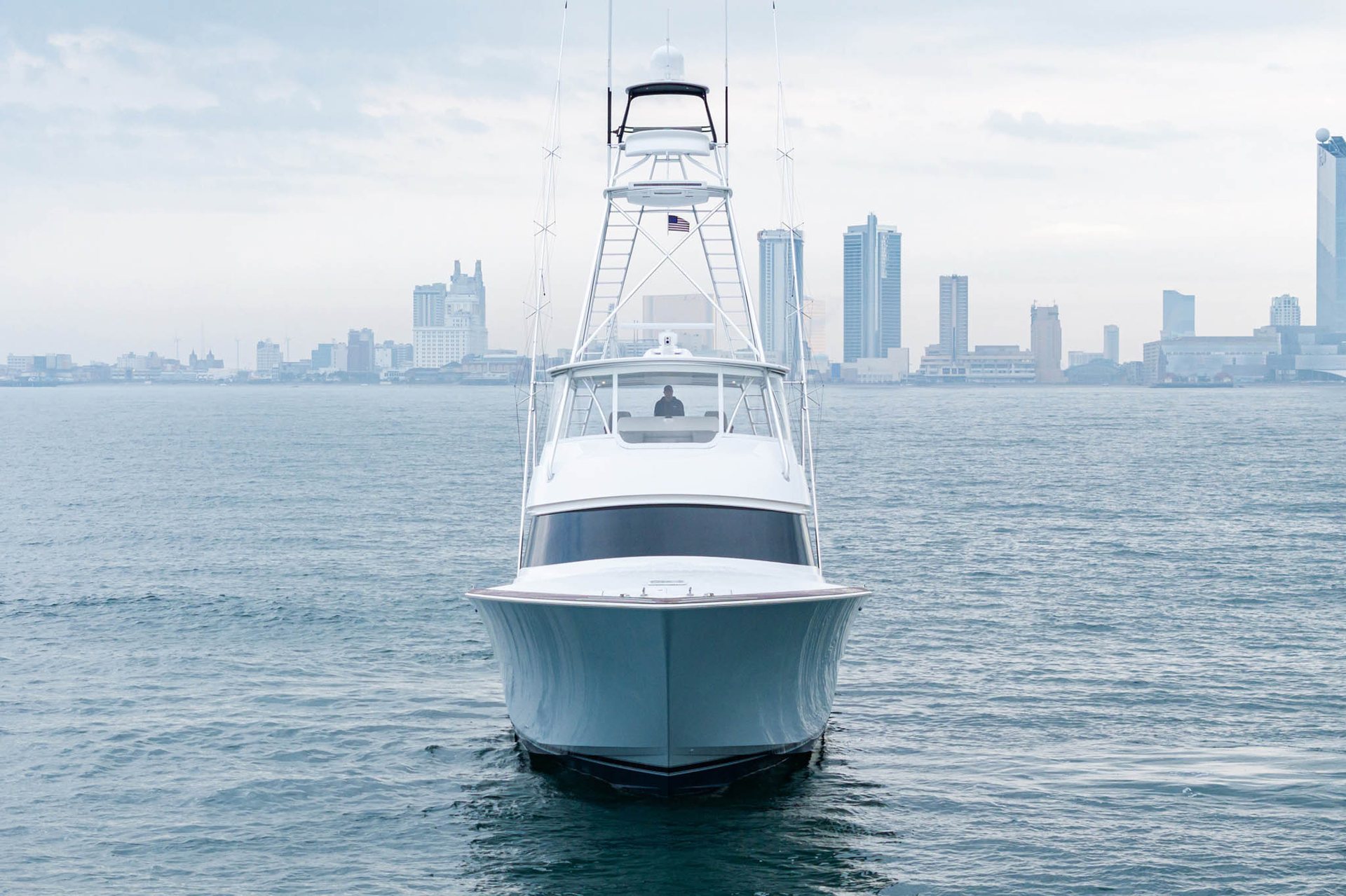 Viking sportfishing convertible running bow-on with a city skyline behind it