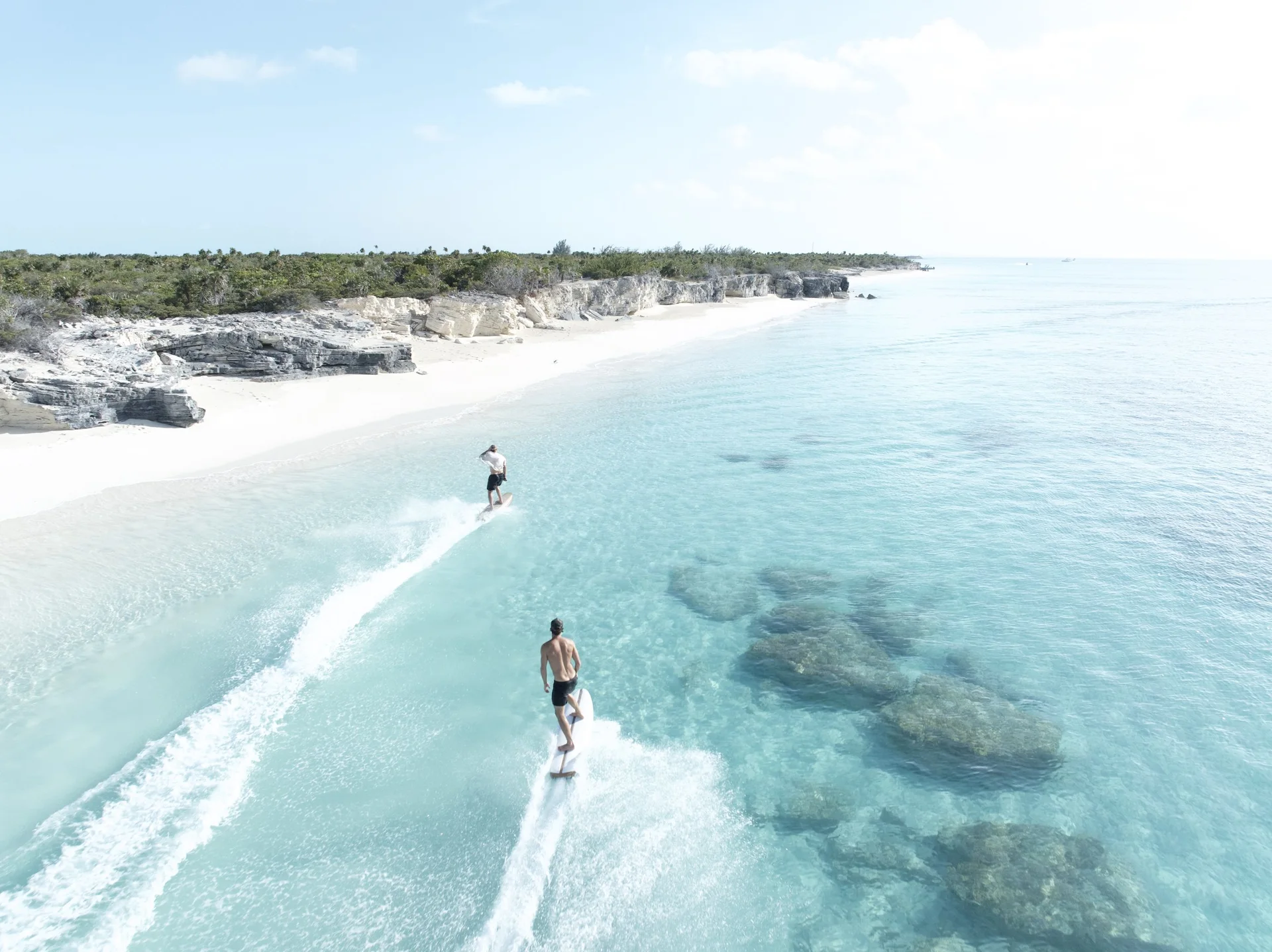 Rider crossing clear shallow water beside an empty Turks and Caicos beach