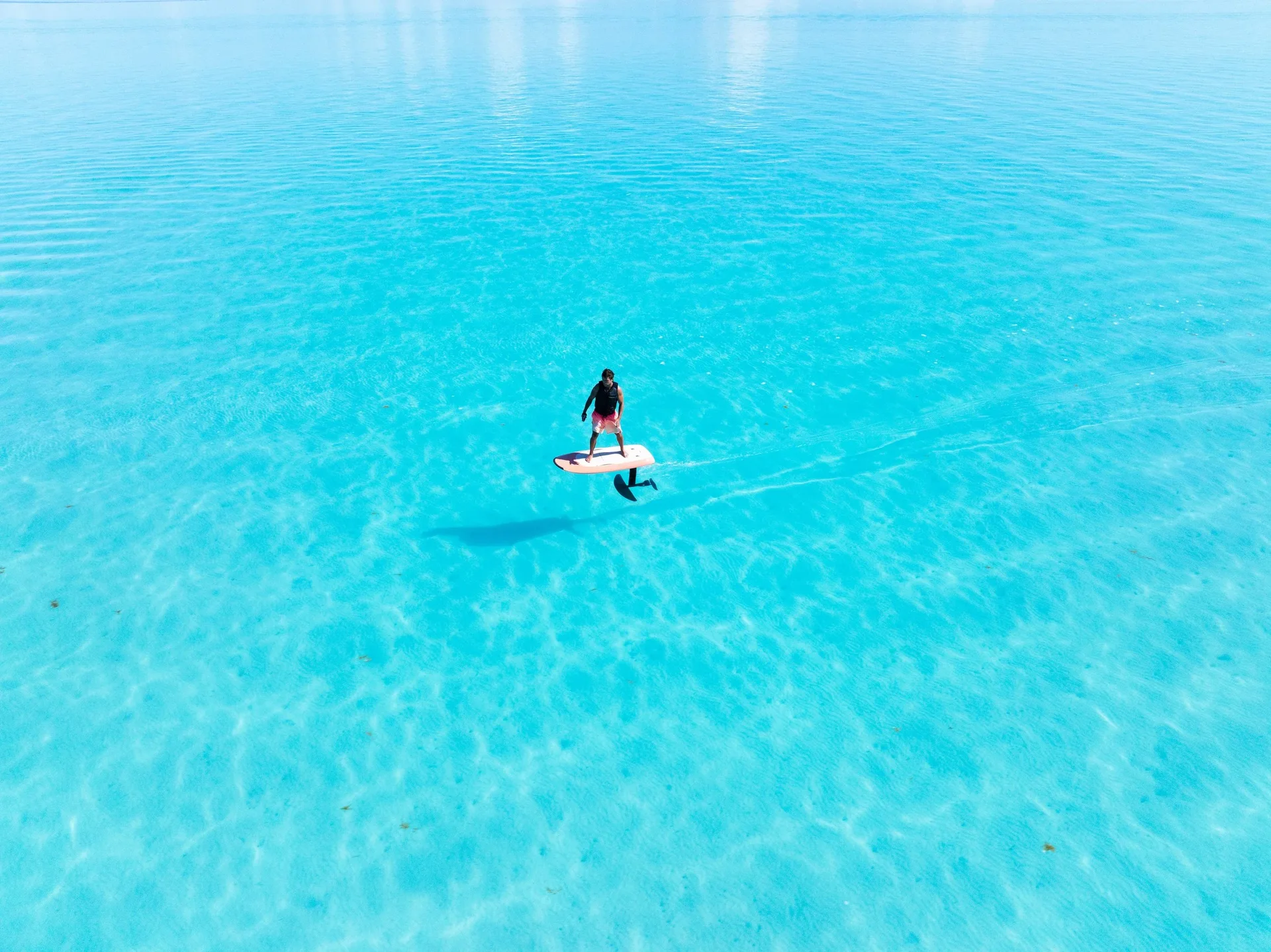 Rider on an eFoil crossing deep blue open water off Providenciales