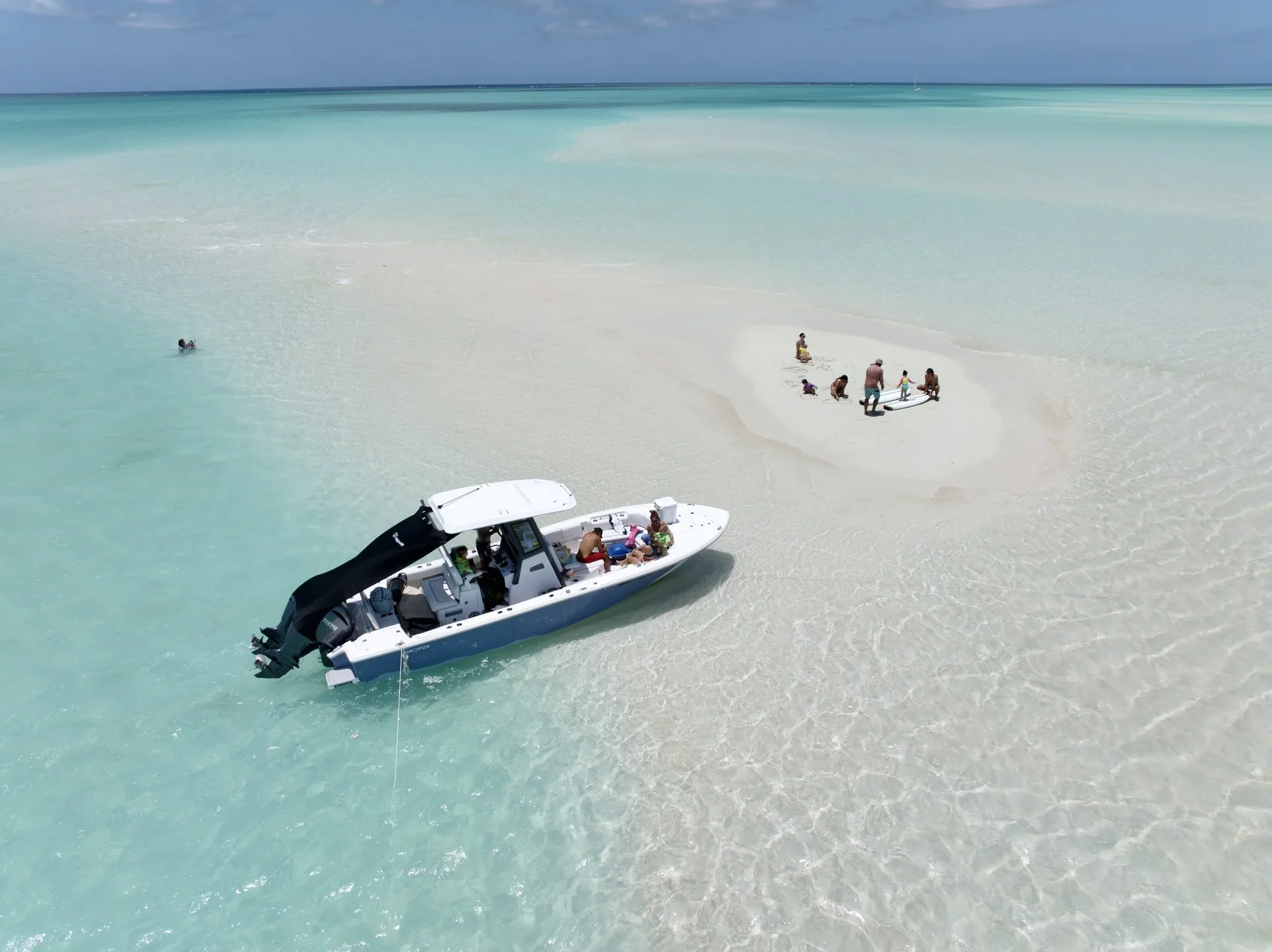 Aerial view of a Wake to Wake boat anchored beside a sandbar in clear shallow water