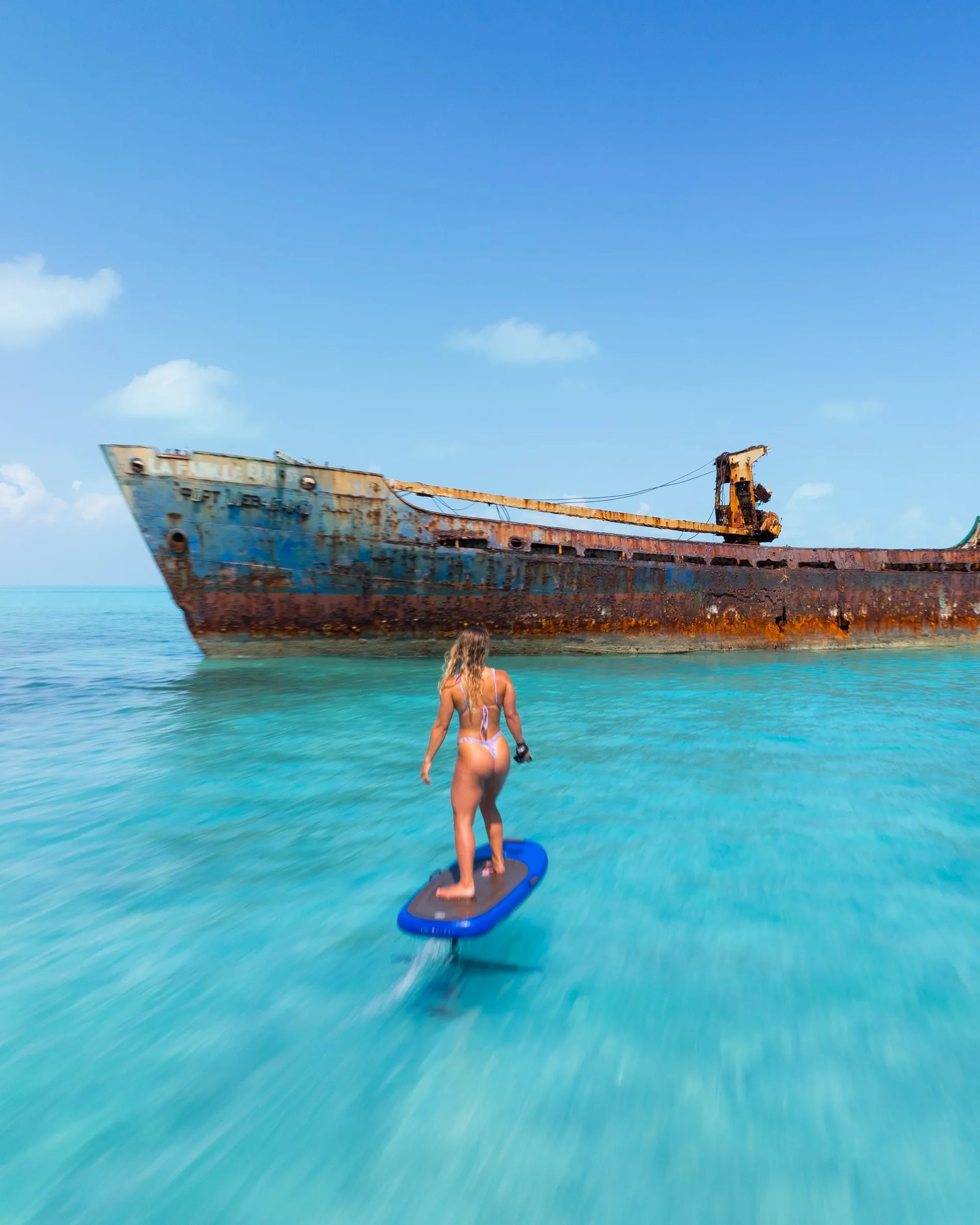 Paddler on flat water beside a shipwreck off Providenciales